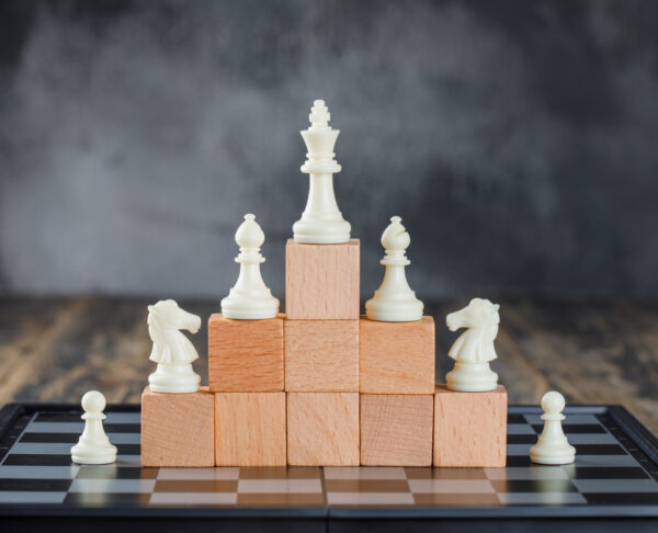 business-hierarchy-concept-with-chessboard-figures-pyramid-wooden-blocks-foggy-wooden-table-side-view (2)